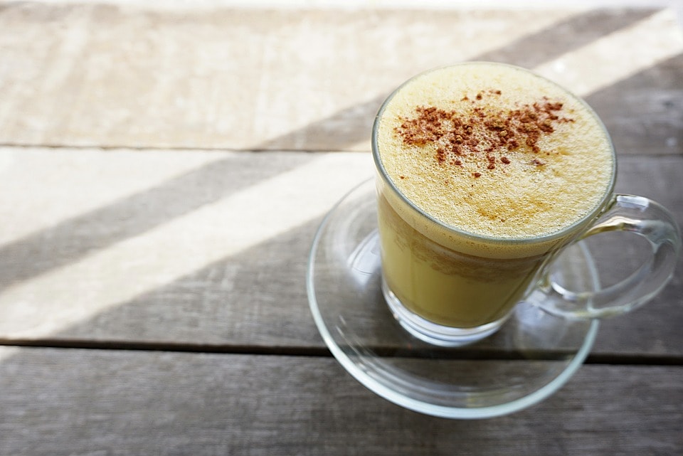 Eine Tasse mit goldener Milch und Schaum - eine gute Routine am Morgen.